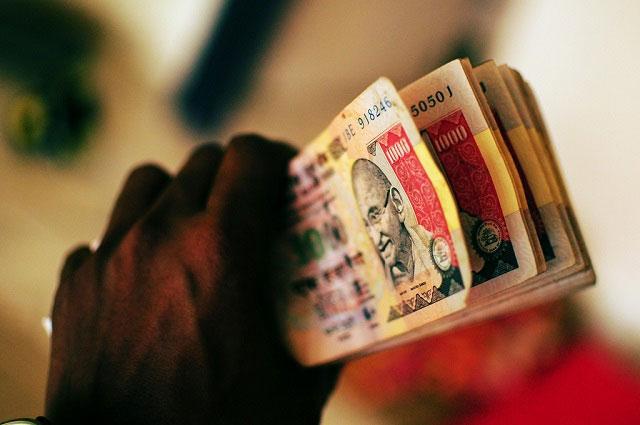 Rupee drops on devaluation report; govt denies move