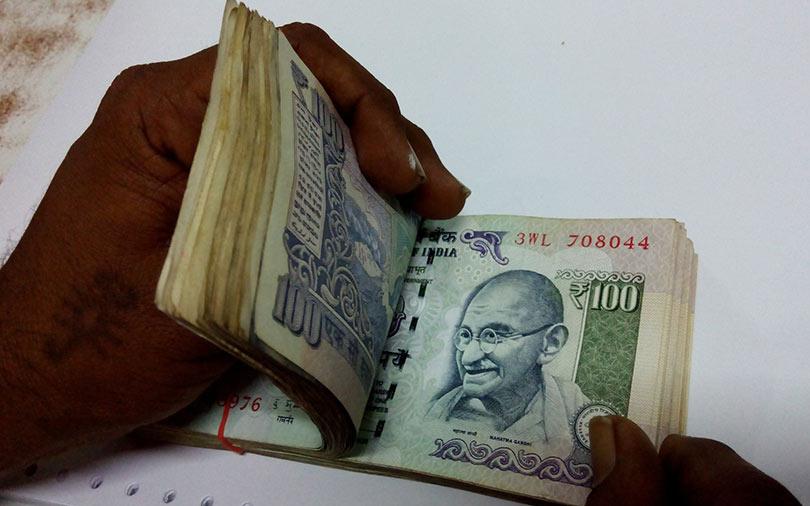 Rupee hits record low on dollar's strength, wider trade deficit