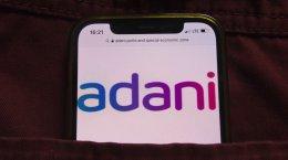 Adani Group cuts revenue growth target, capex
